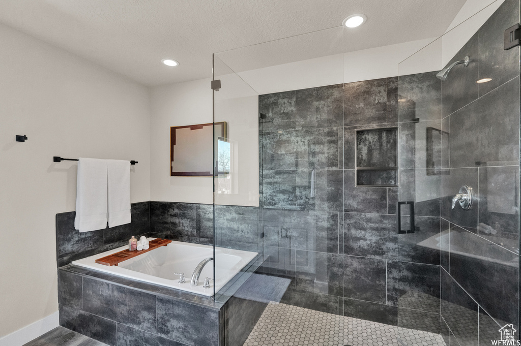 Bathroom featuring a garden tub and a shower stall
