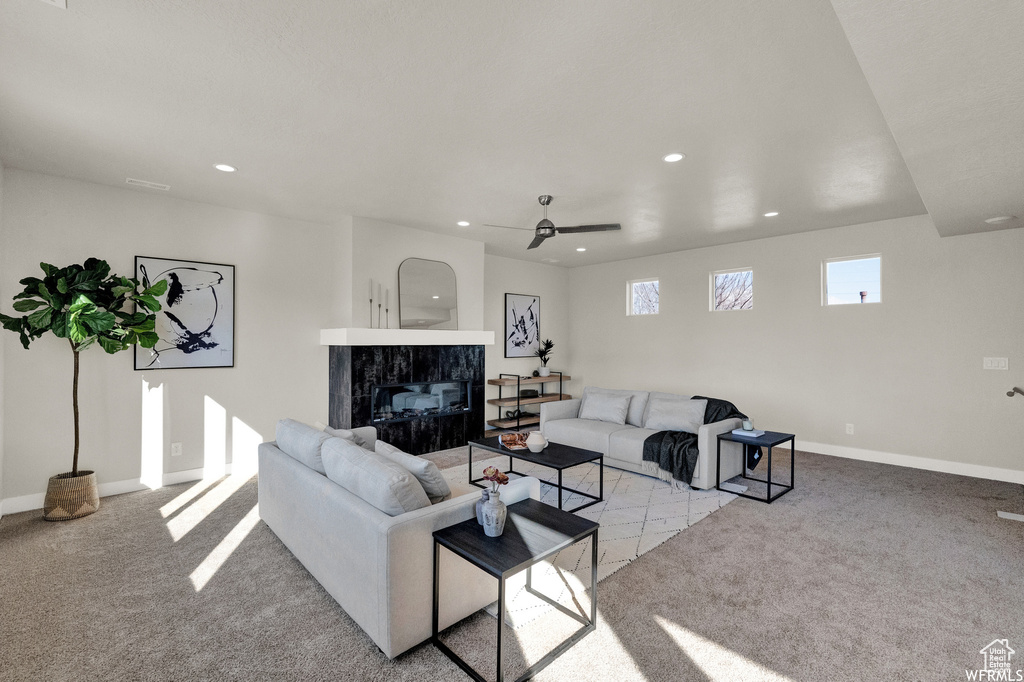 Living area with recessed lighting, light carpet, a fireplace, ceiling fan, and baseboards