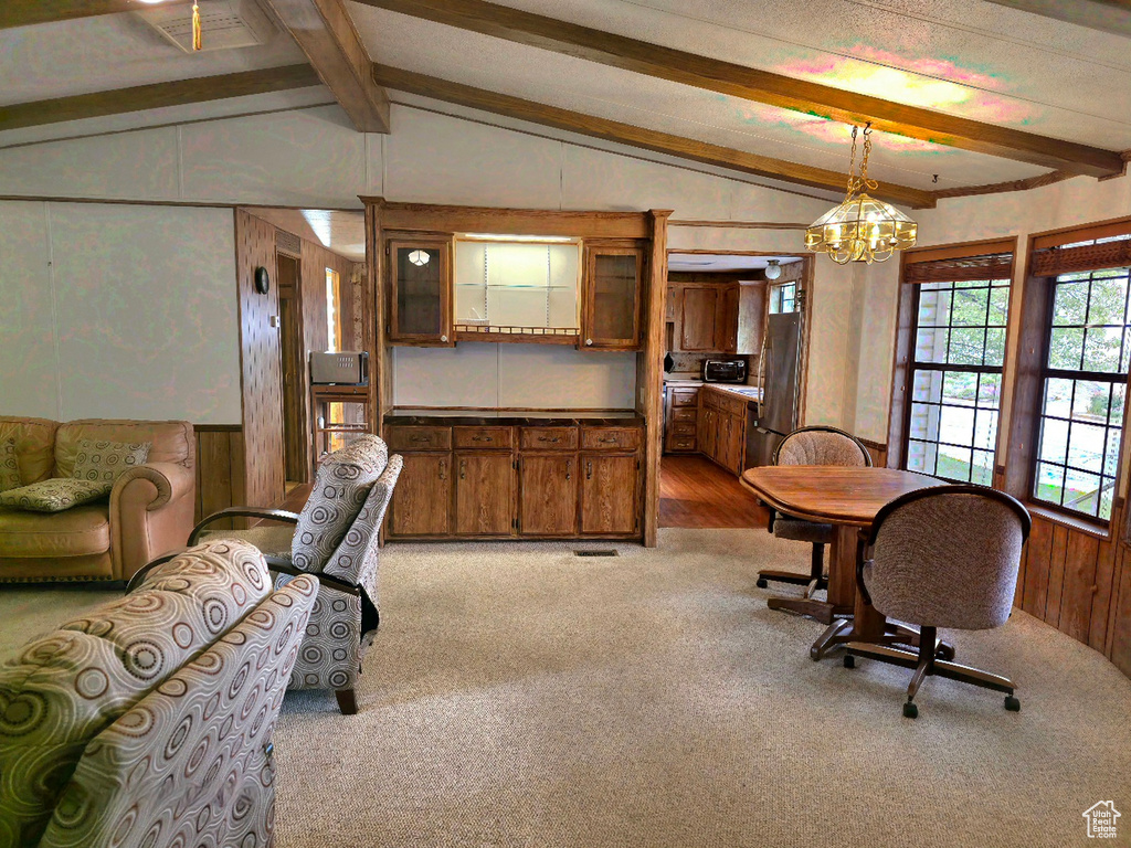 Dining space featuring carpet flooring and a chandelier