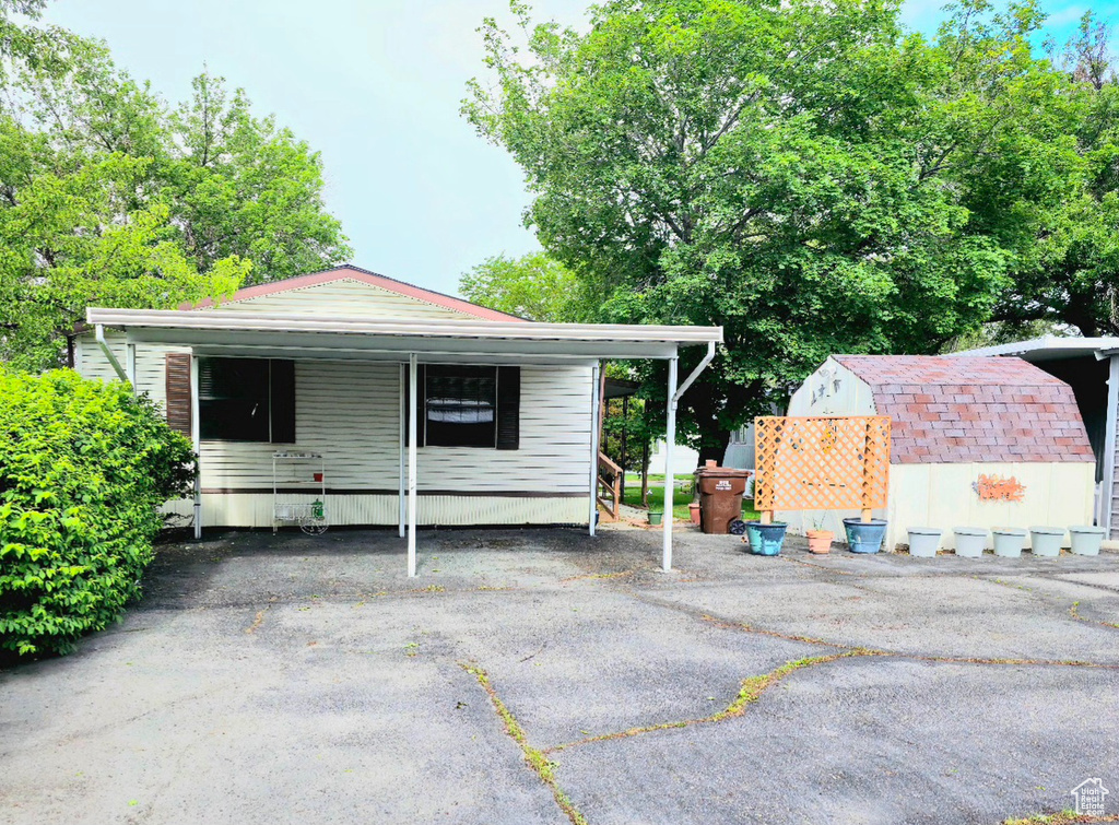 View of front of house featuring an outbuilding and a shed