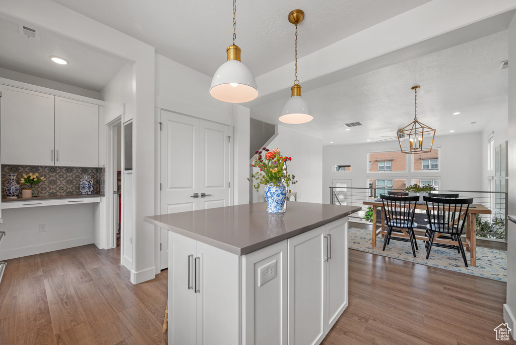 Kitchen featuring light wood-style flooring, white cabinets, a chandelier, a kitchen island, and recessed lighting