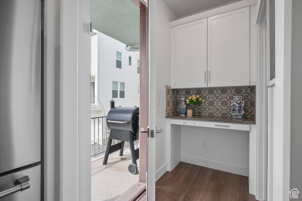 Hallway featuring a desk and dark wood-style floors