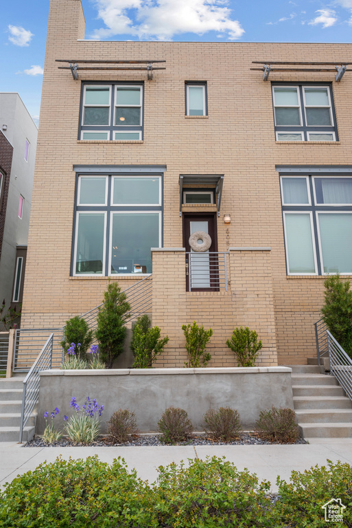 View of front of house with brick siding and stairs