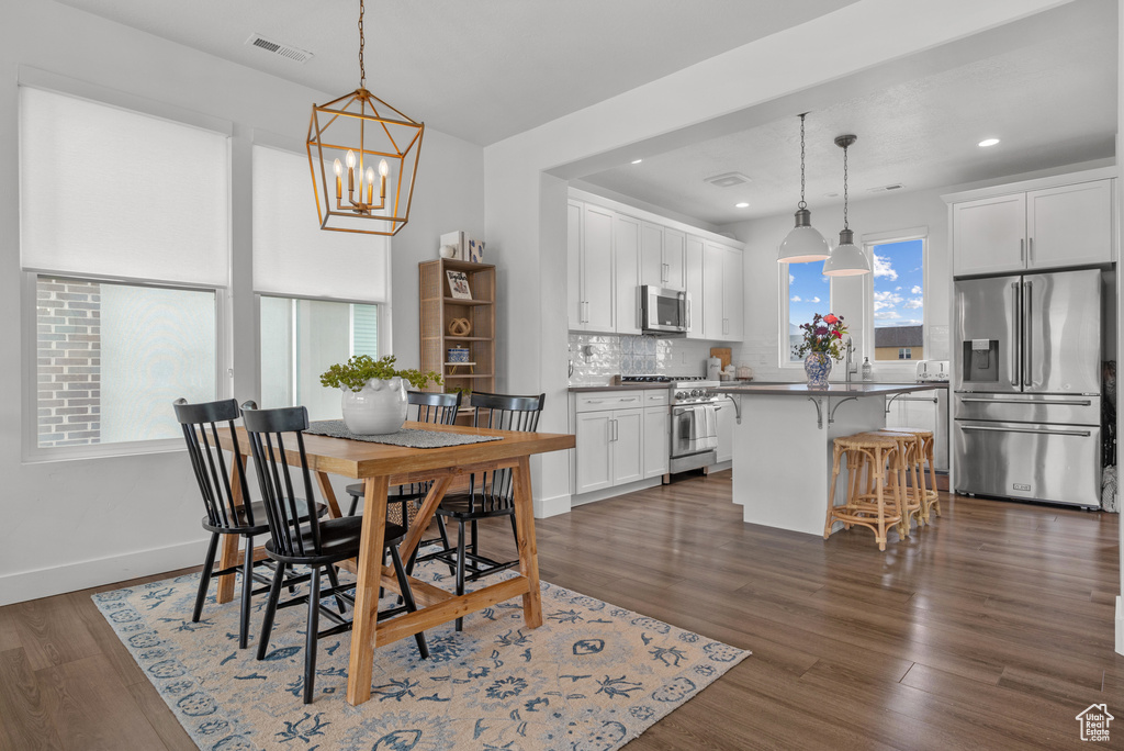 Dining area featuring a chandelier, recessed lighting, dark wood-type flooring, and baseboards