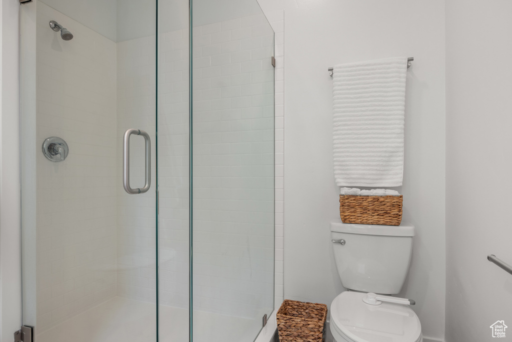 Bathroom with a shower stall, toilet, and baseboards