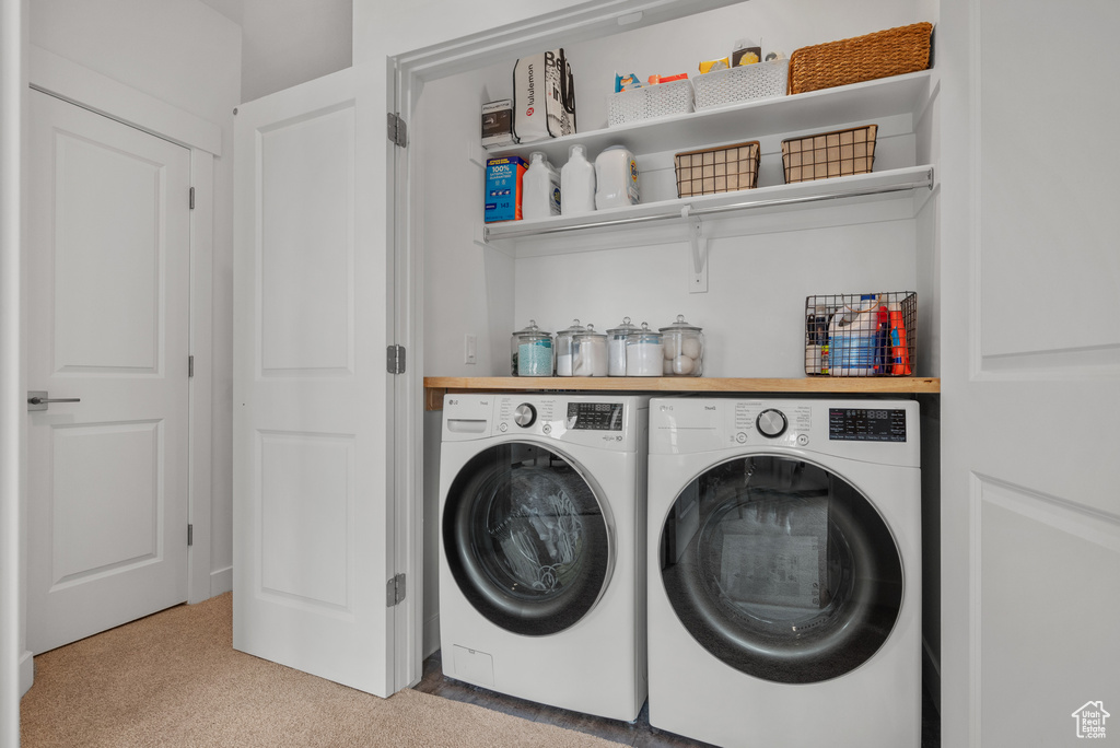Laundry area featuring independent washer and dryer and light carpet