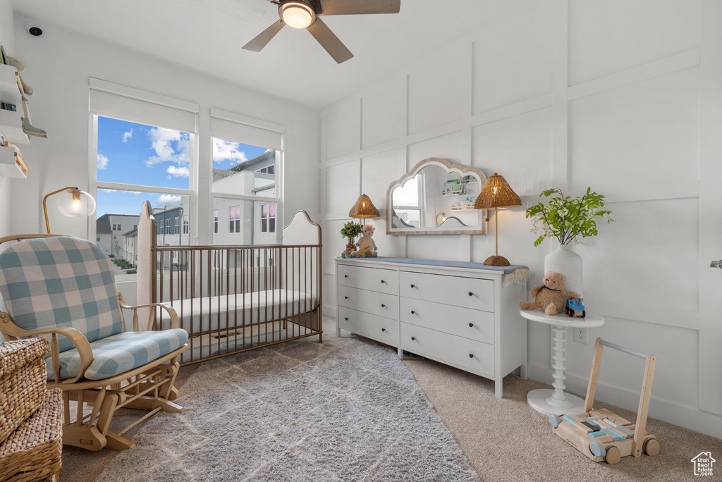 Carpeted bedroom featuring a nursery area