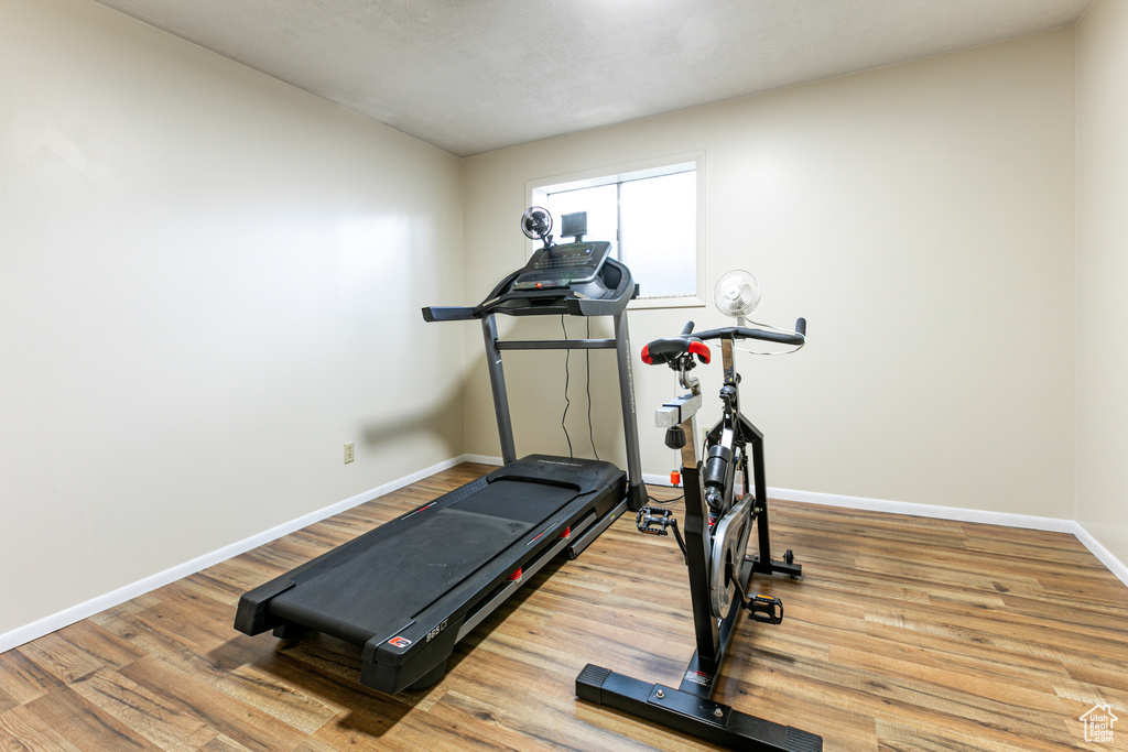 Workout area featuring baseboards and wood finished floors