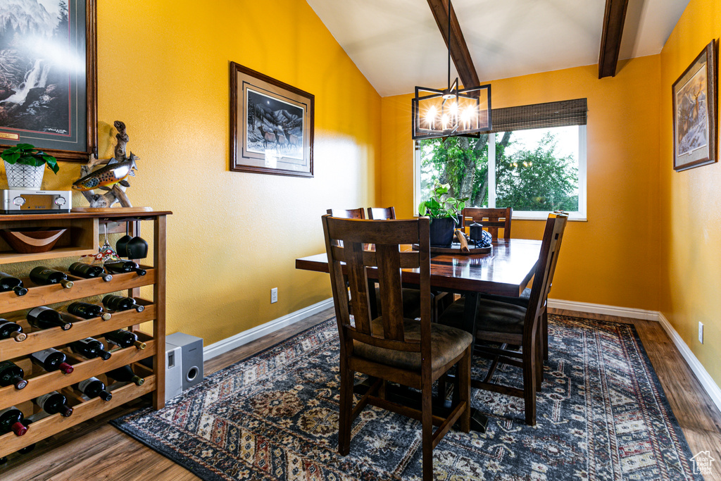 Dining room featuring wood finished floors, baseboards, and a chandelier