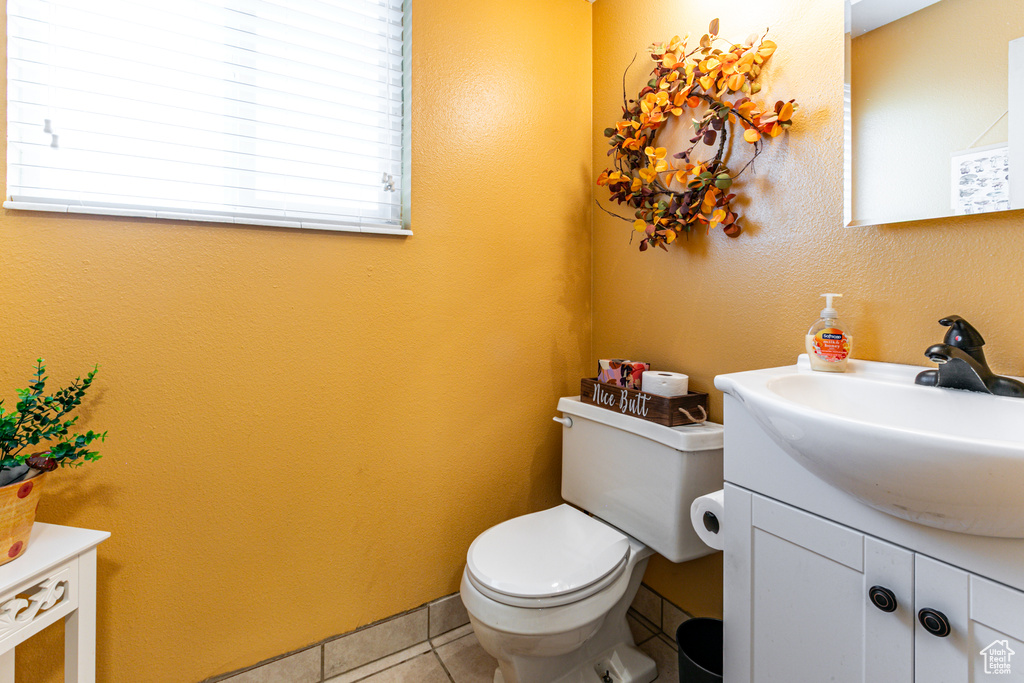 Half bath featuring vanity, tile patterned floors, and toilet