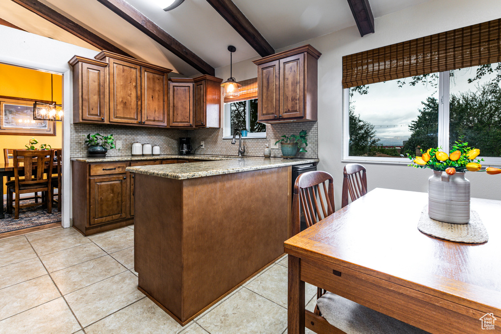 Kitchen featuring decorative backsplash, light stone counters, pendant lighting, and light tile patterned flooring