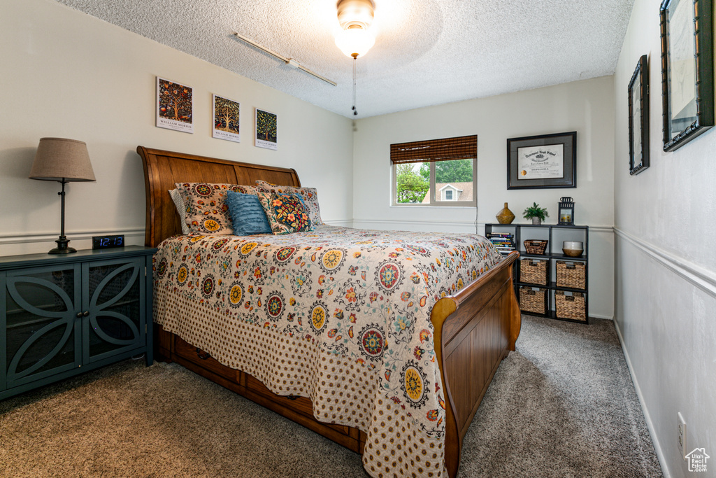 Bedroom with carpet, a textured ceiling, and a ceiling fan