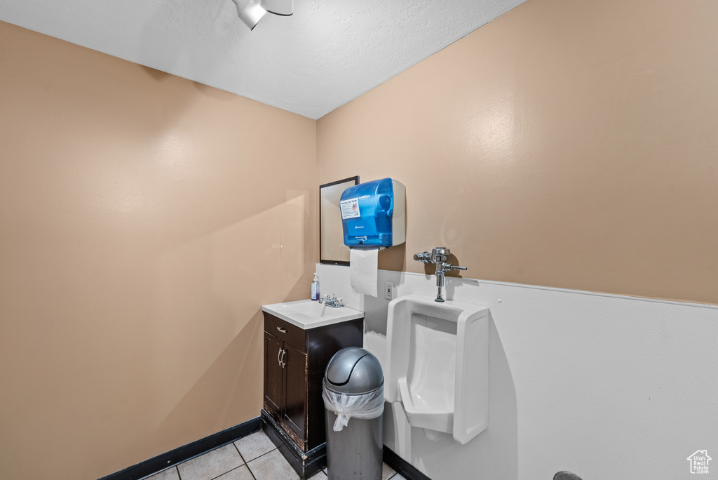 Bathroom with tile patterned flooring, vanity, pet washing station, and baseboards