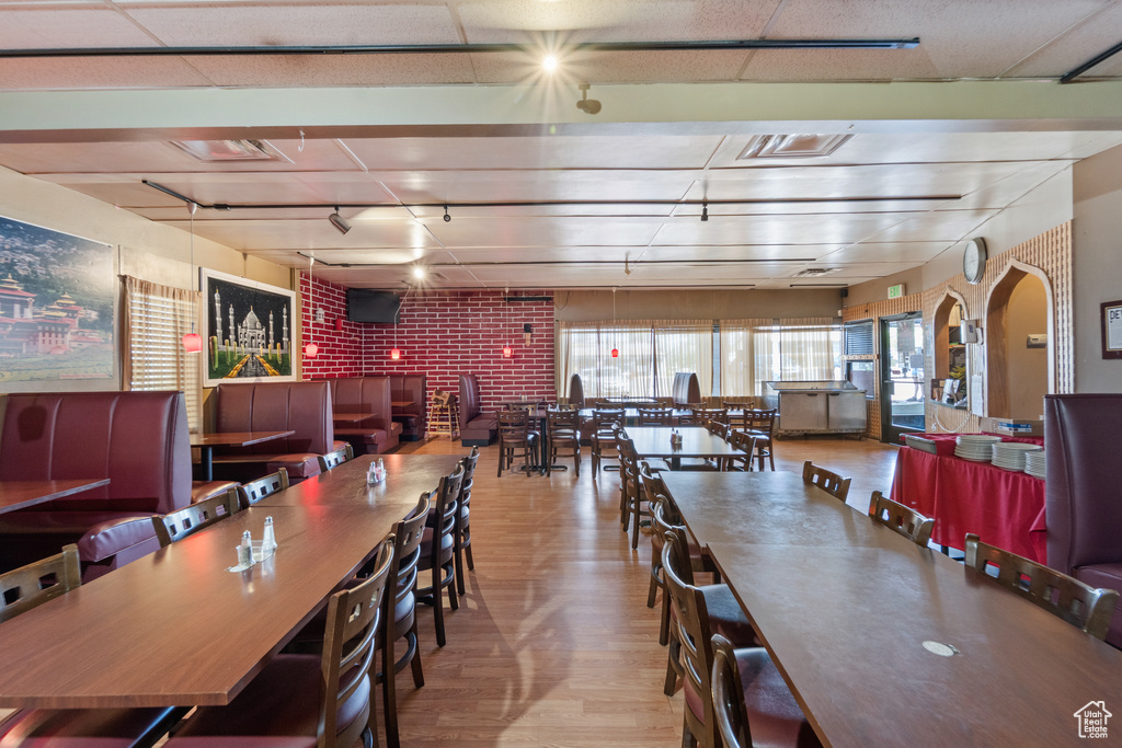 Dining space featuring wood finished floors, arched walkways, and track lighting