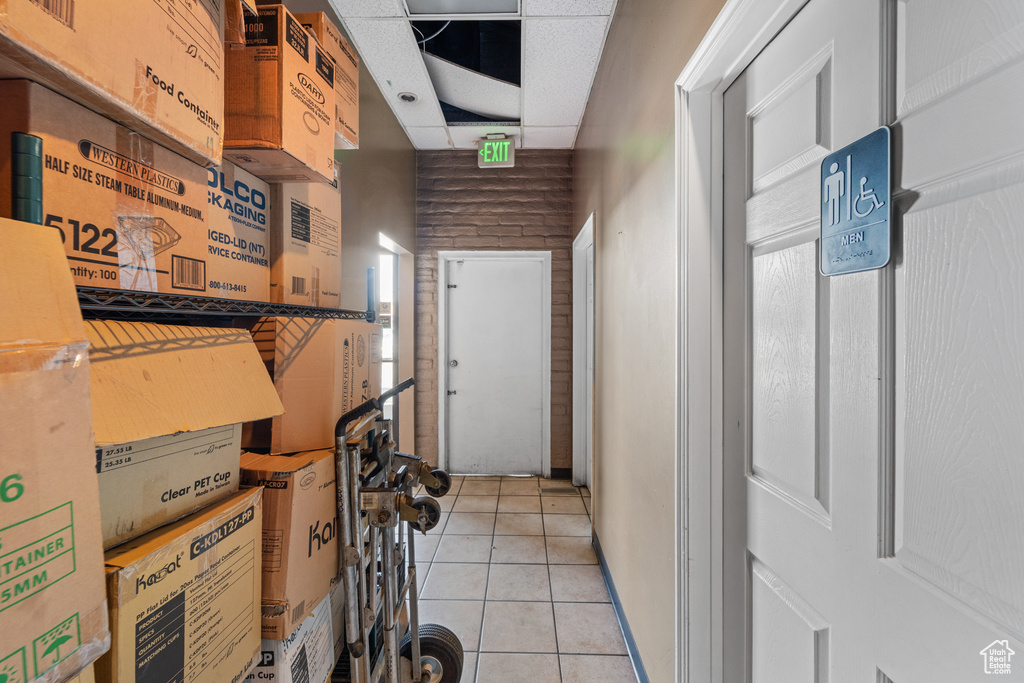 Corridor with light tile patterned floors and a drop ceiling