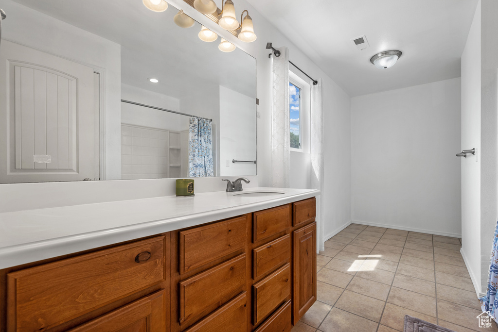 Bathroom with tile patterned floors, vanity, baseboards, and a shower with shower curtain