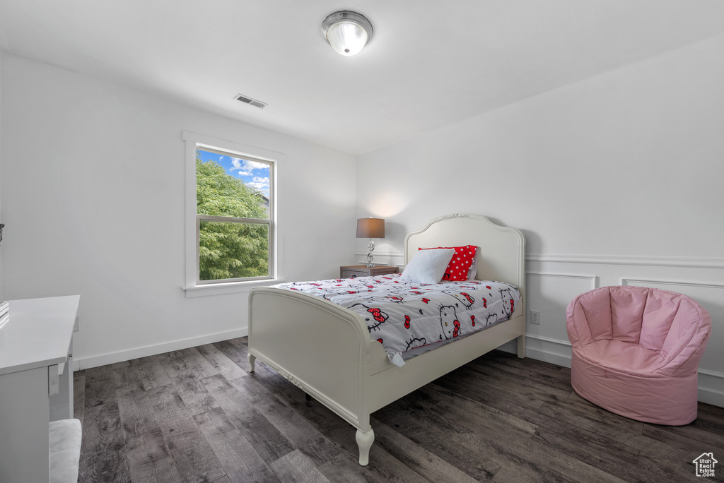 Bedroom with wood finished floors and baseboards