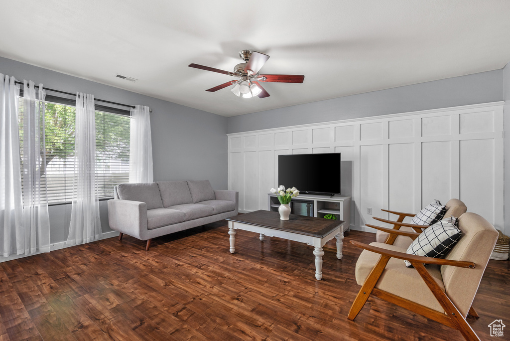 Living room featuring ceiling fan and dark wood finished floors