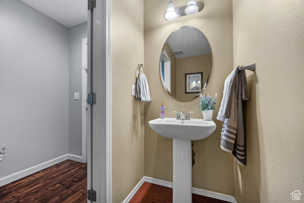 Bathroom with wood finished floors, baseboards, and a sink