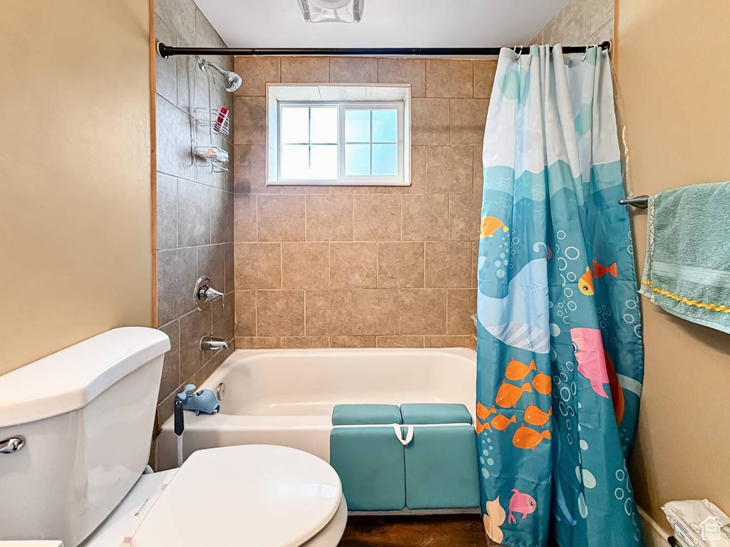 Full bath featuring shower / bathtub combination with curtain and toilet
