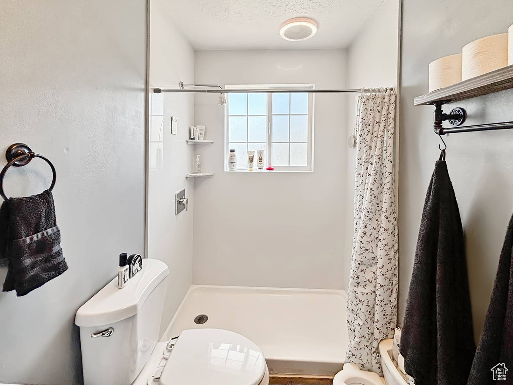 Full bath with toilet and a stall shower