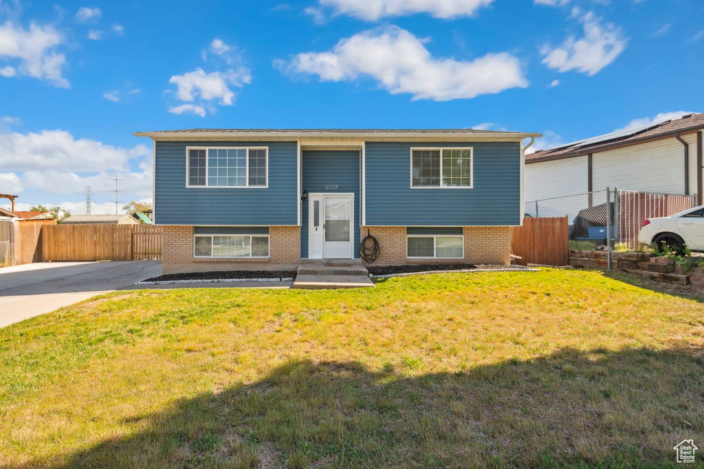 Raised ranch featuring brick siding, entry steps, and concrete driveway