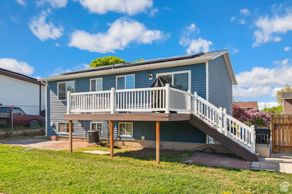 Rear view of house featuring a wooden deck, central AC unit, a patio area, and stairway