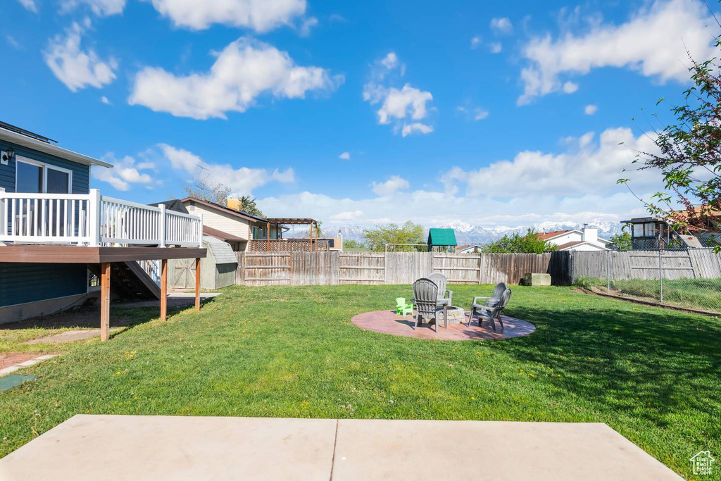 View of yard with a deck, a patio, stairway, and a fire pit