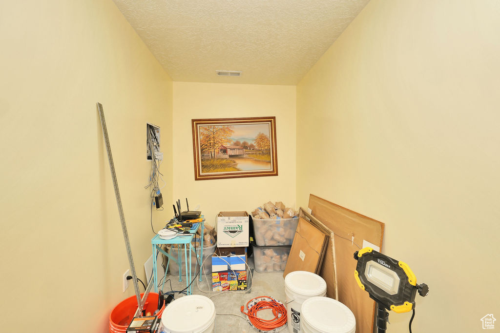 Bathroom with a textured ceiling and toilet