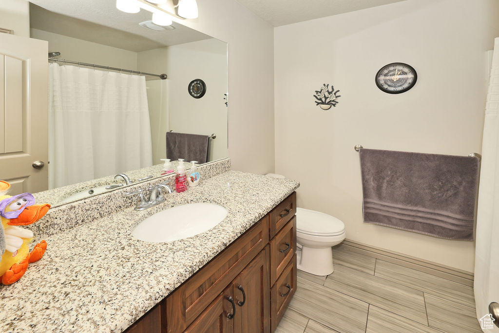 Full bathroom with vanity, toilet, and a shower with shower curtain