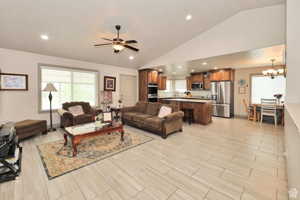 Living room with lofted ceiling, ceiling fan, a chandelier, and recessed lighting