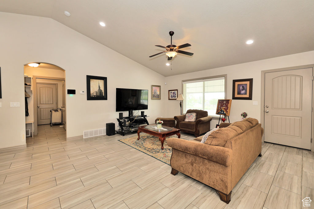 Living area with arched walkways, a ceiling fan, recessed lighting, and high vaulted ceiling