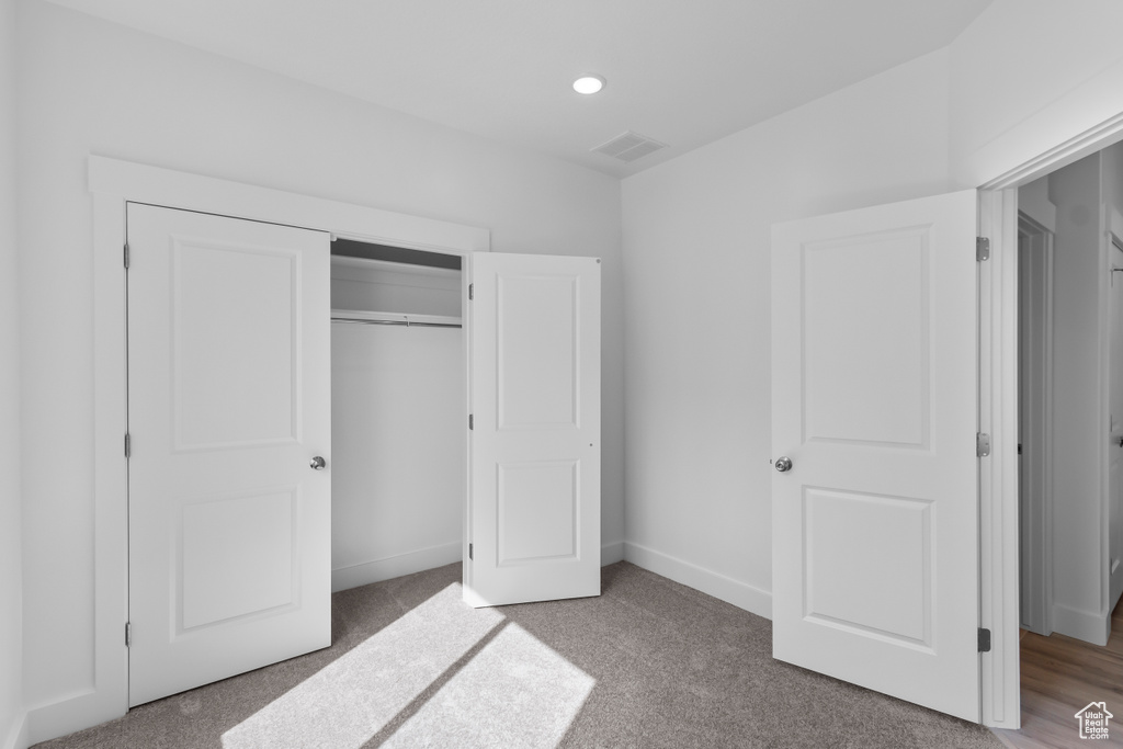 Unfurnished bedroom featuring carpet floors, recessed lighting, a closet, and baseboards