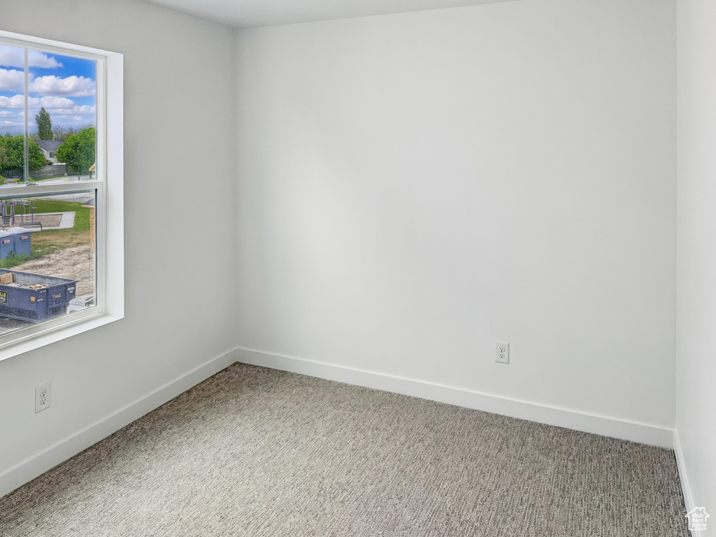 Carpeted empty room with baseboards