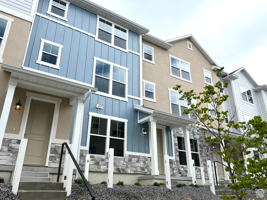 View of property featuring board and batten siding and stone siding