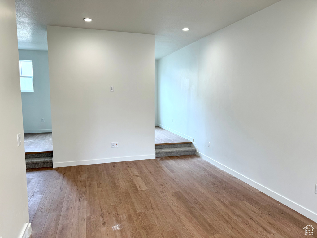 Spare room featuring wood finished floors, baseboards, and recessed lighting