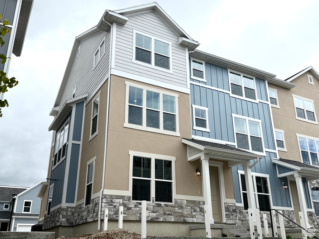 View of front of home with stone siding and board and batten siding