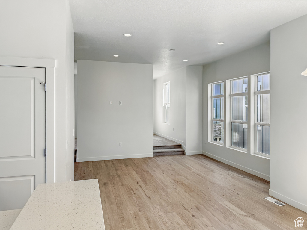 Empty room with recessed lighting, baseboards, and light wood finished floors