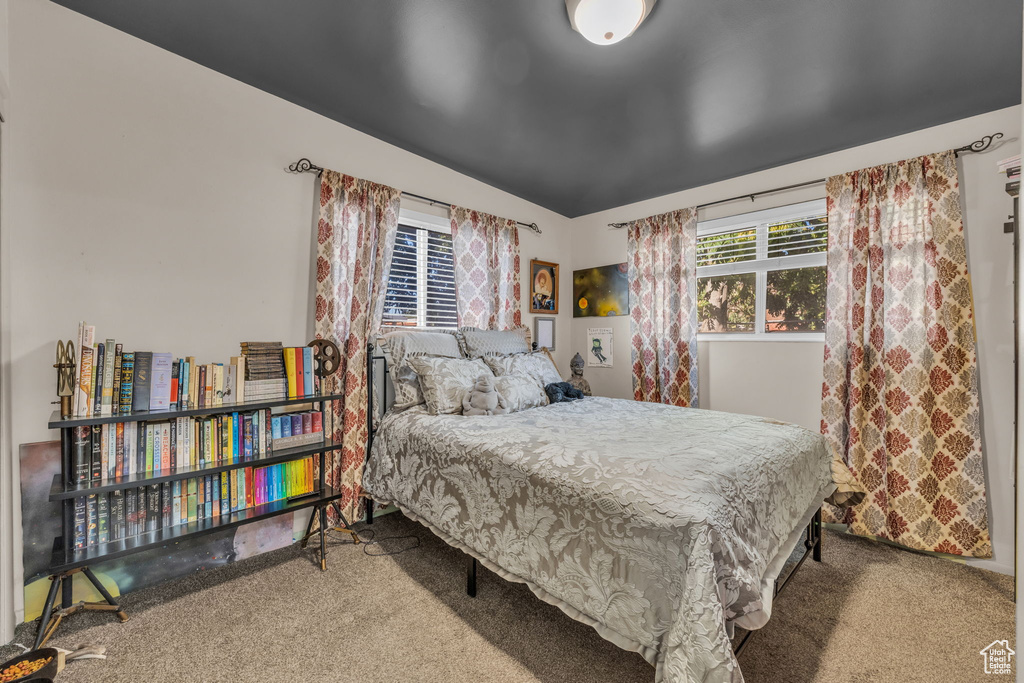 Carpeted bedroom featuring lofted ceiling