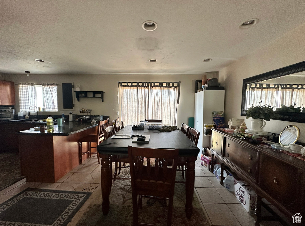 Tiled dining area with recessed lighting and a textured ceiling