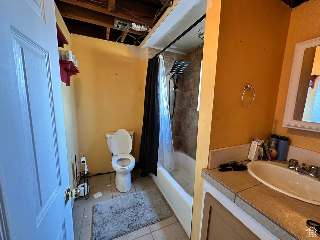Bathroom with tile patterned floors, toilet, vanity, and shower / bath combination with curtain