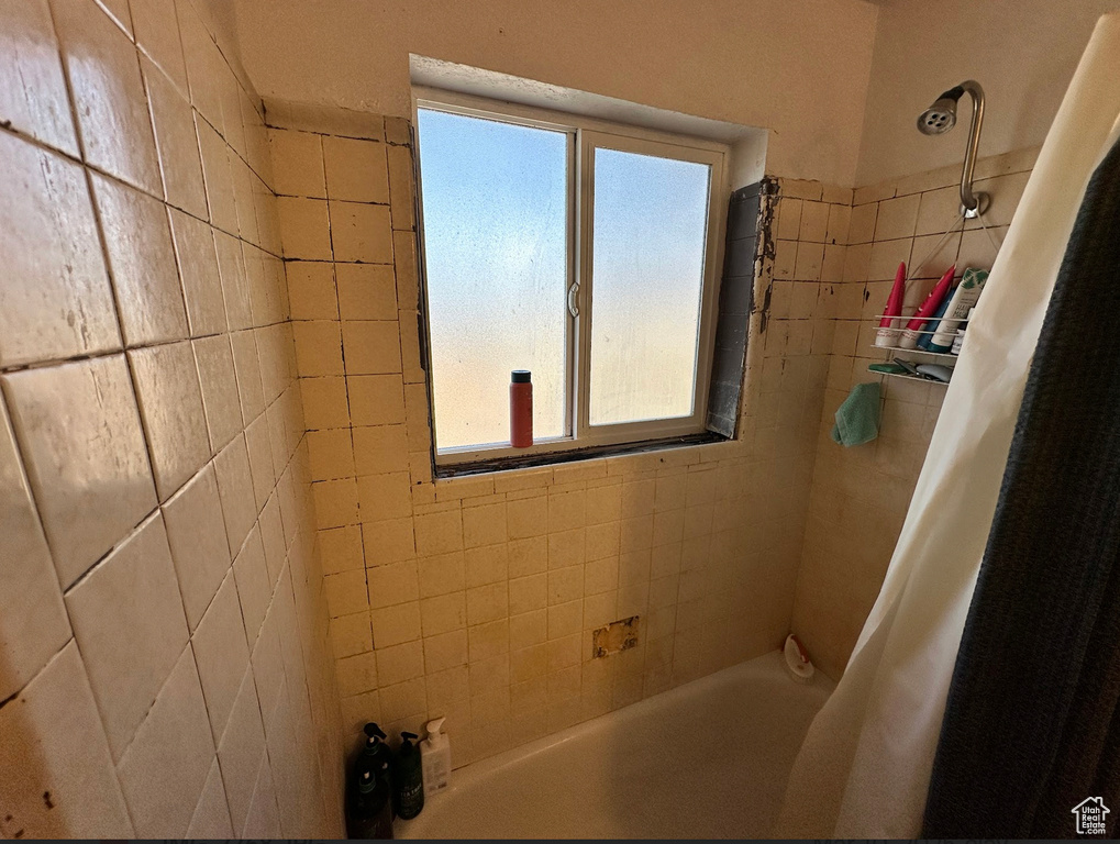 Bathroom featuring plenty of natural light and shower / tub combo