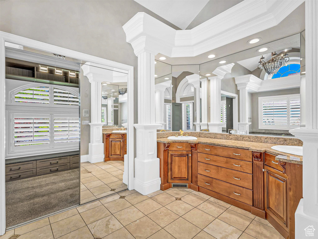 Full bathroom featuring decorative columns, tile patterned floors, double vanity, recessed lighting, and lofted ceiling