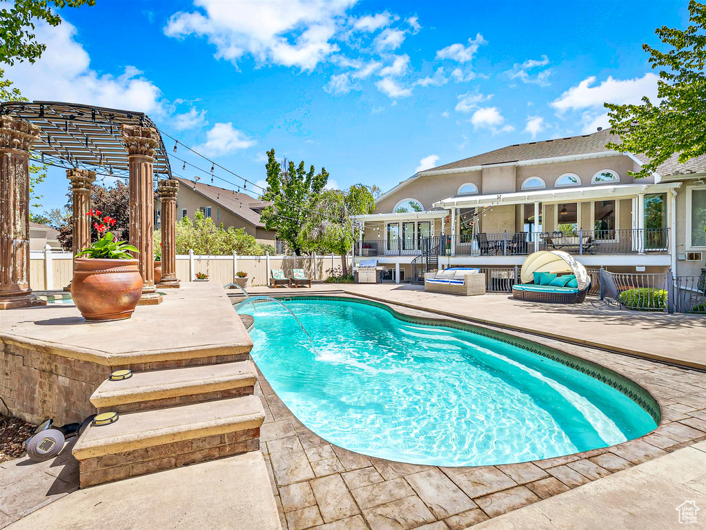 View of swimming pool with a patio area and fence