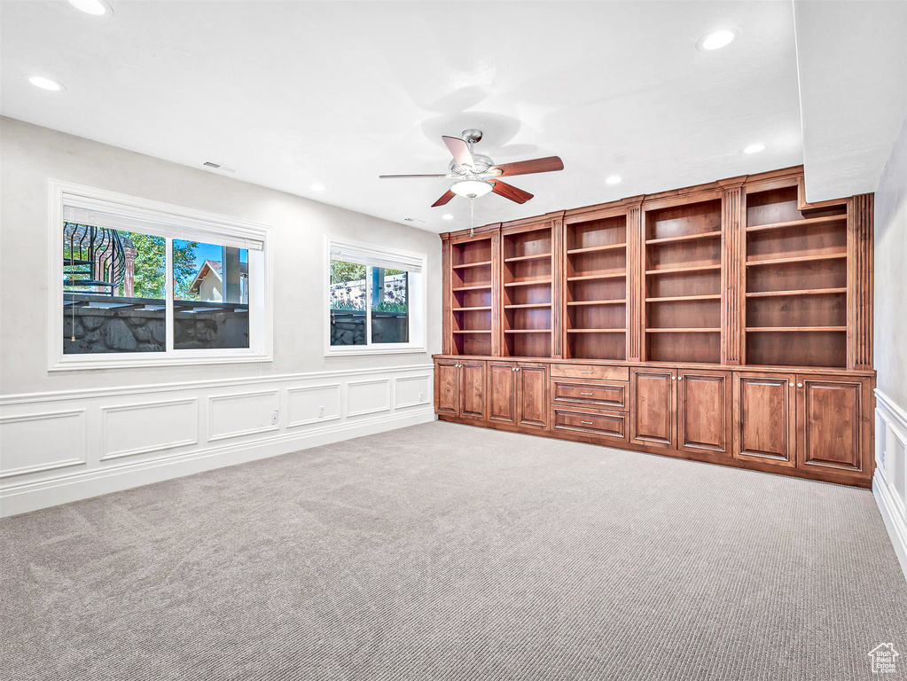 Unfurnished living room with recessed lighting, carpet floors, a ceiling fan, and a decorative wall