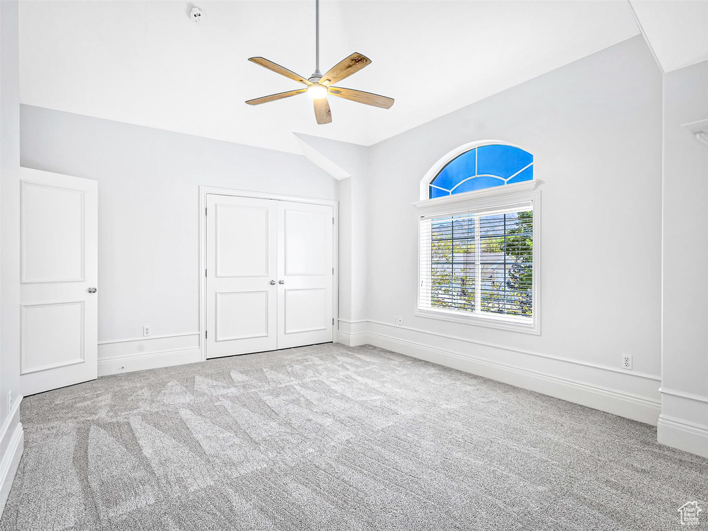 Unfurnished bedroom with carpet flooring, a closet, baseboards, and a ceiling fan