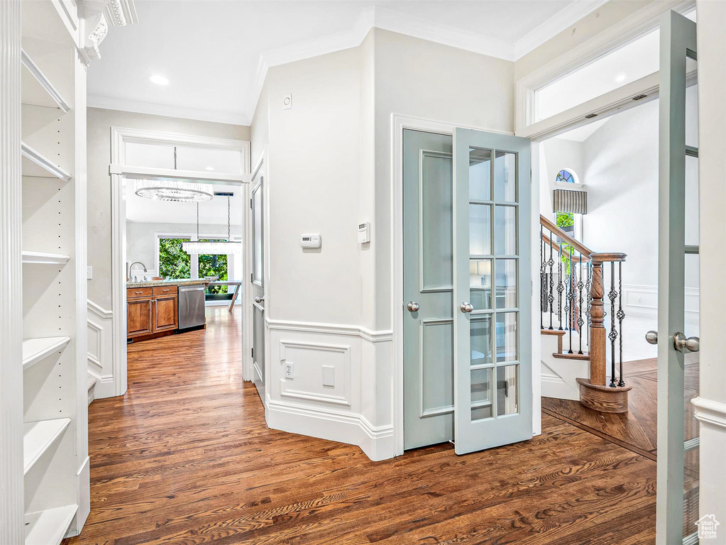 Entrance foyer featuring crown molding, wood finished floors, and stairway