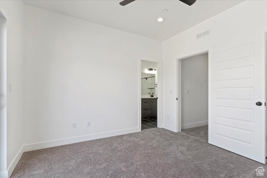 Unfurnished bedroom with carpet flooring, baseboards, ensuite bathroom, arched walkways, and recessed lighting