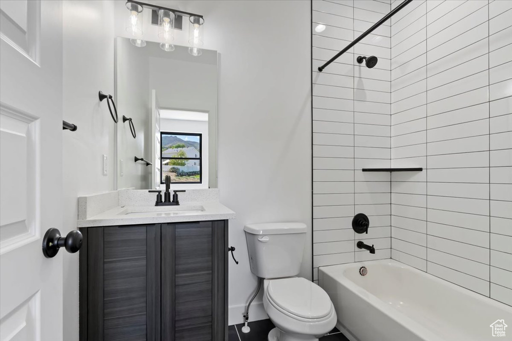 Bathroom with toilet, vanity, shower / bath combination, and baseboards