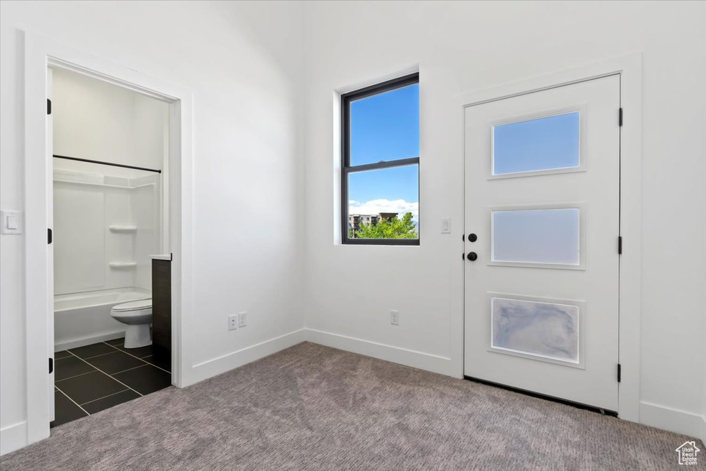 Foyer entrance featuring carpet flooring, baseboards, and tile patterned flooring
